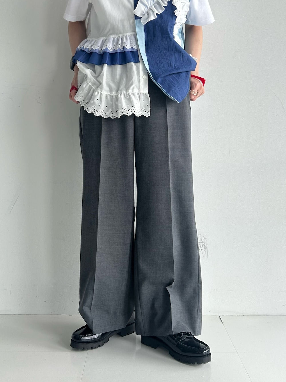 グレー系のスラックス、ブラック系のローファー、ホワイト系のTシャツ/カットソーを着用したレディースの春コーディネートの6枚目の写真