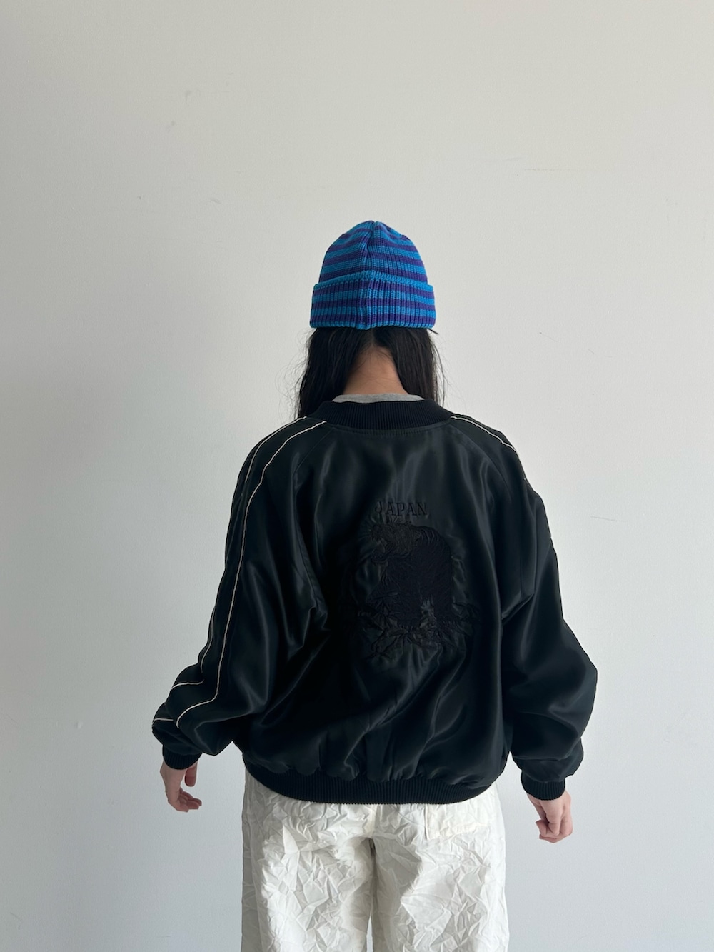 ホワイト系のスラックス、ブルー系のスカジャン、ホワイト系のタンクトップを着用したレディースの春コーディネートの8枚目の写真