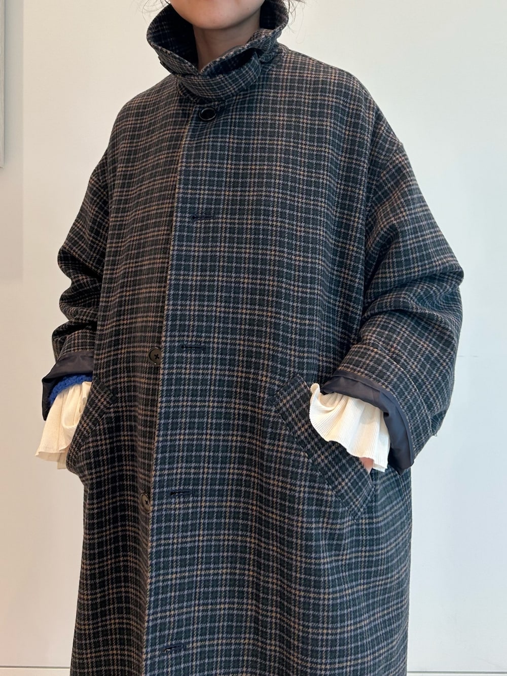 ブルー系のステンカラーコート、ホワイト系のTシャツ/カットソー、ブルー系のカーディガン/ボレロを着用したレディースの秋コーディネートの4枚目の写真