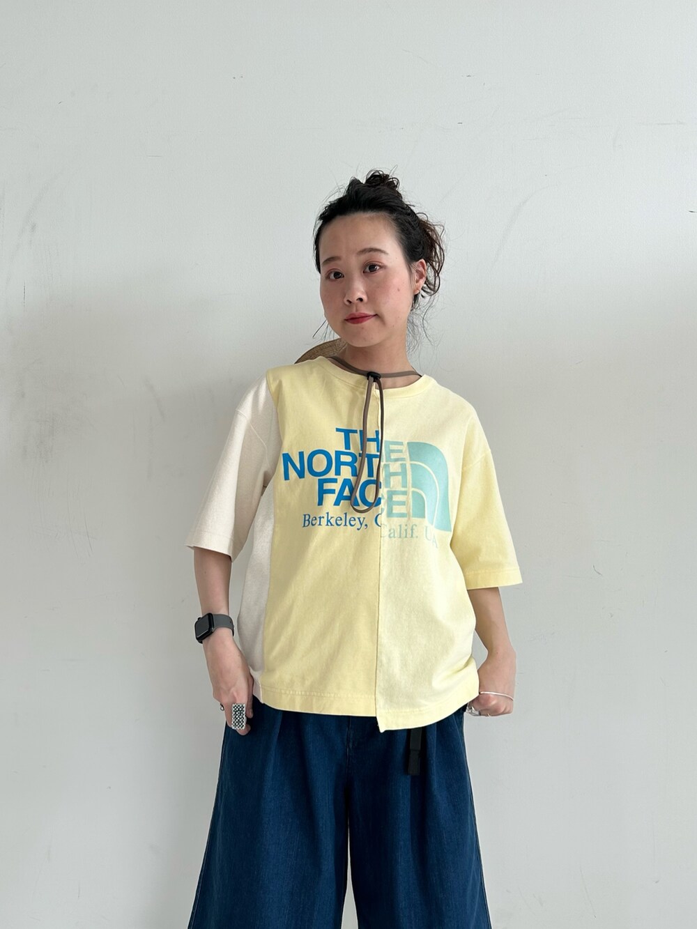ブラウン系のバックパック/リュック、ブルー系のデニムパンツ、ベージュ系のローファーを着用したレディースの春コーディネートの4枚目の写真