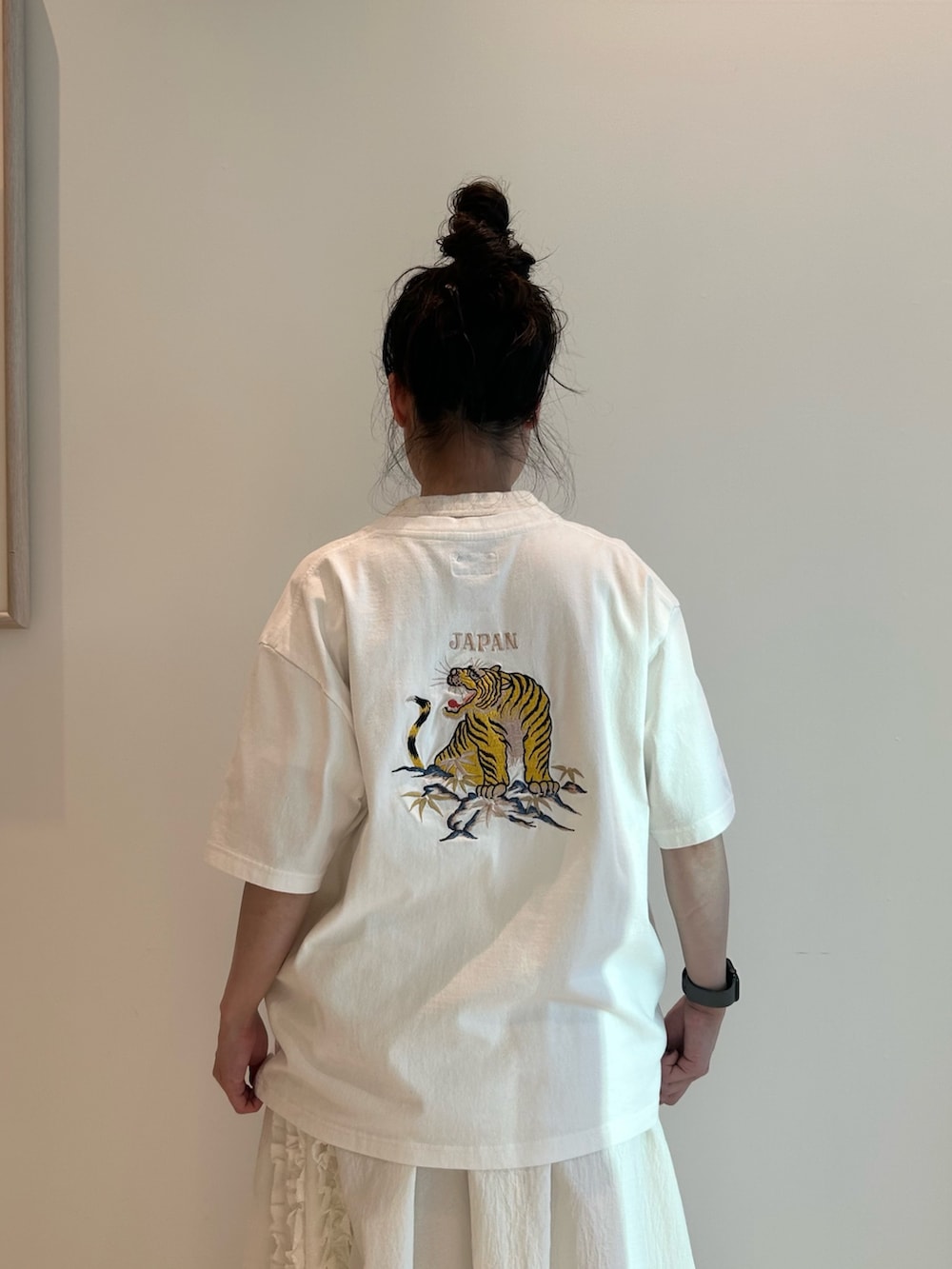 ブルー系のスカジャン、ホワイト系のスカート、ブラック系のローファーを着用したレディースの春コーディネートの7枚目の写真