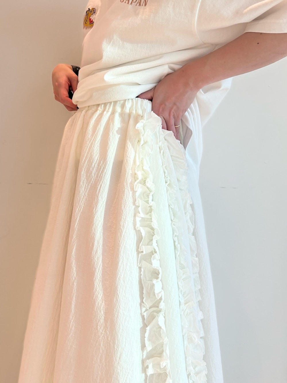 ブルー系のスカジャン、ホワイト系のスカート、ブラック系のローファーを着用したレディースの春コーディネートの9枚目の写真