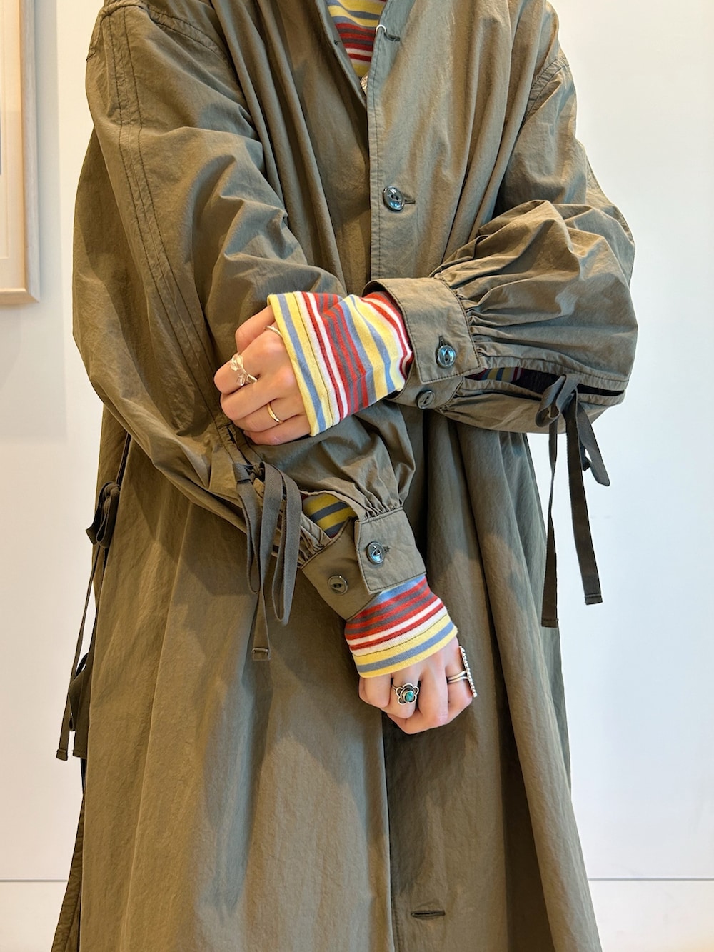 グリーン系のブルゾン、グリーン系のワンピース、イエロー系のTシャツ/カットソーを着用したレディースの秋コーディネートの10枚目の写真