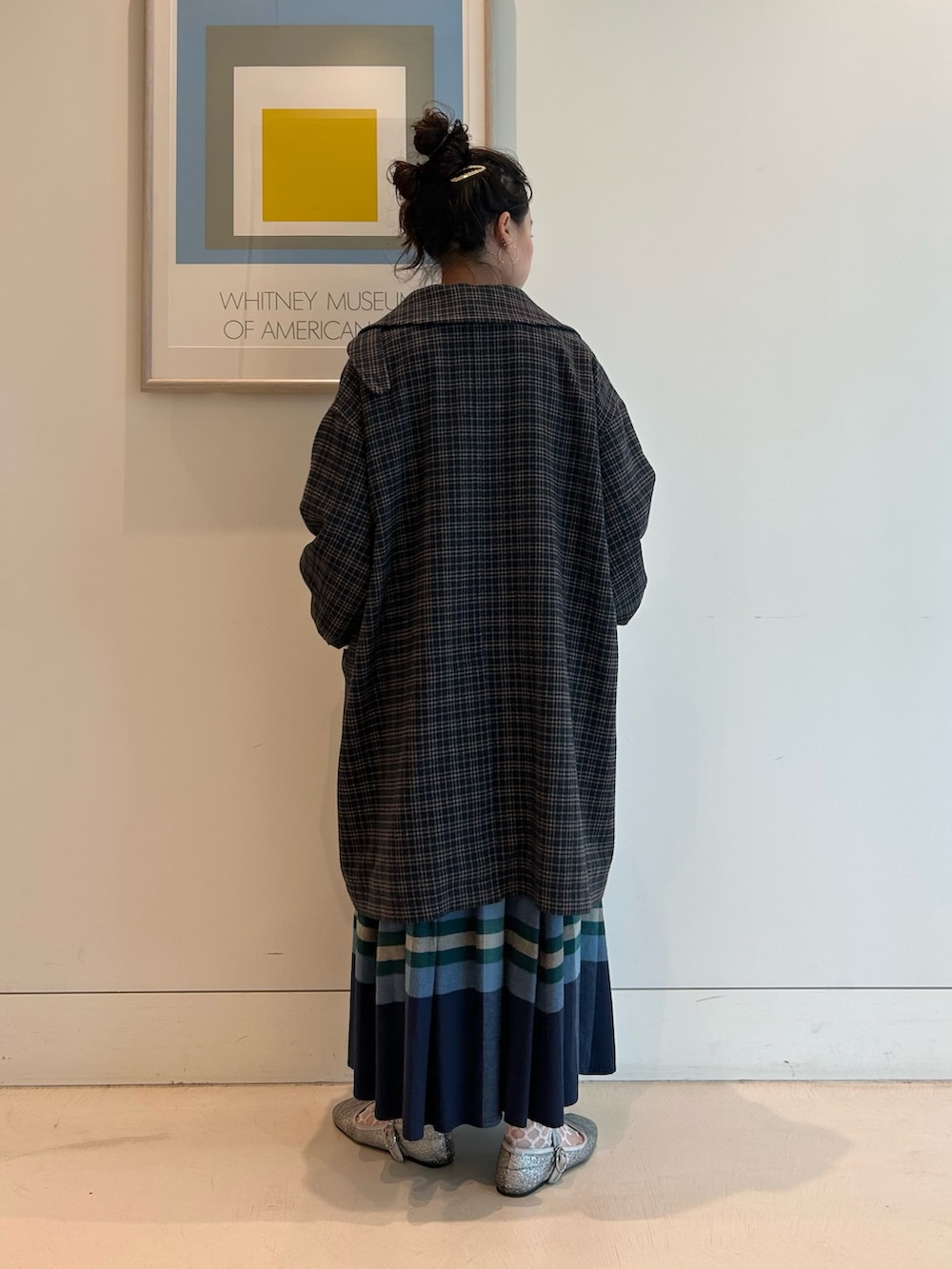 ブルー系のステンカラーコート、ホワイト系のTシャツ/カットソー、ブルー系のカーディガン/ボレロを着用したレディースの秋コーディネートの3枚目の写真