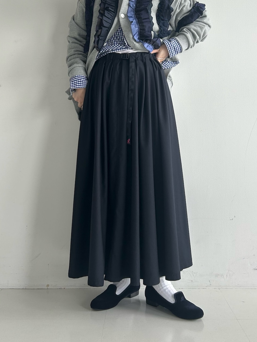 ブルー系のドレスシューズ、ブルー系のスカート、グレー系のカーディガン/ボレロを着用したレディースの秋コーディネートの7枚目の写真