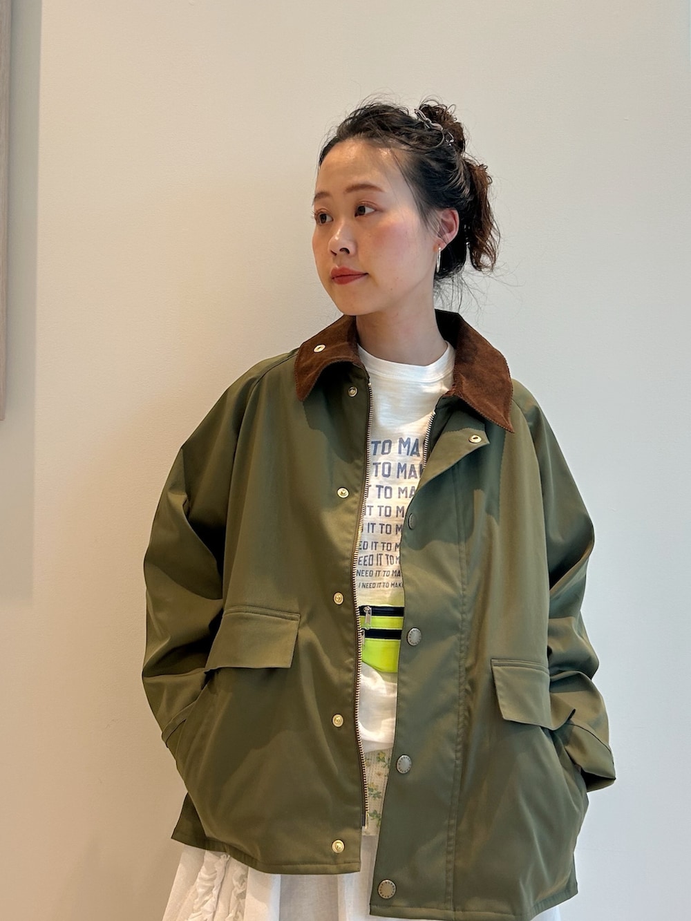 グリーン系のブルゾン、ホワイト系のTシャツ/カットソー、ブルー系のデニムパンツを着用したレディースの冬コーディネートの4枚目の写真