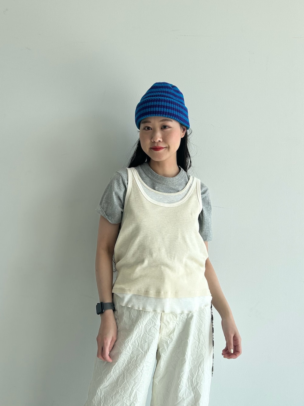 ホワイト系のスラックス、ブルー系のスカジャン、ホワイト系のタンクトップを着用したレディースの春コーディネートの9枚目の写真