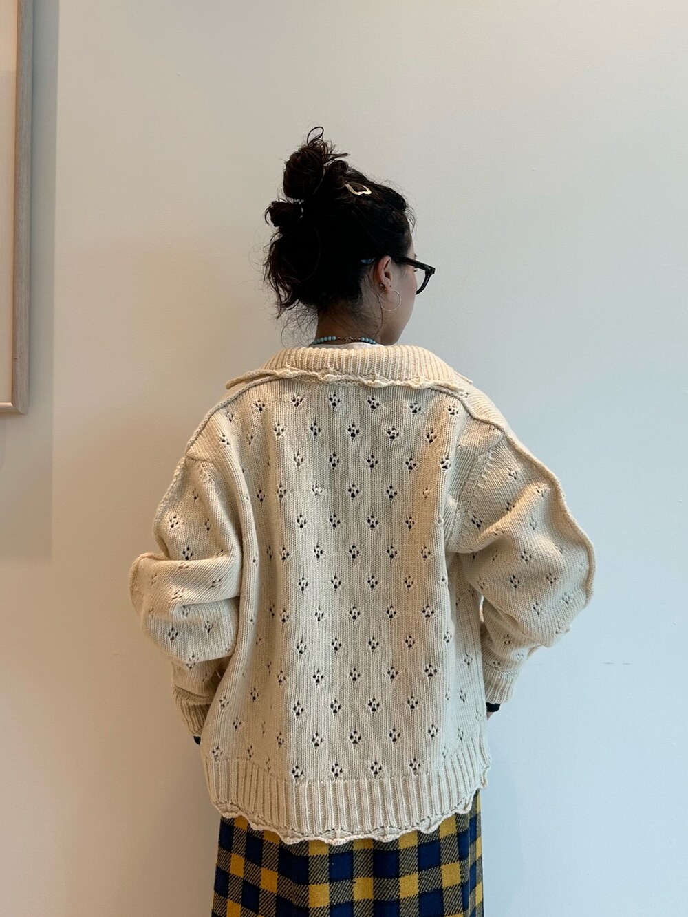 イエロー系のスカート、ホワイト系のカーディガン/ボレロ、ブラック系のメガネを着用したレディースの秋コーディネートの5枚目の写真