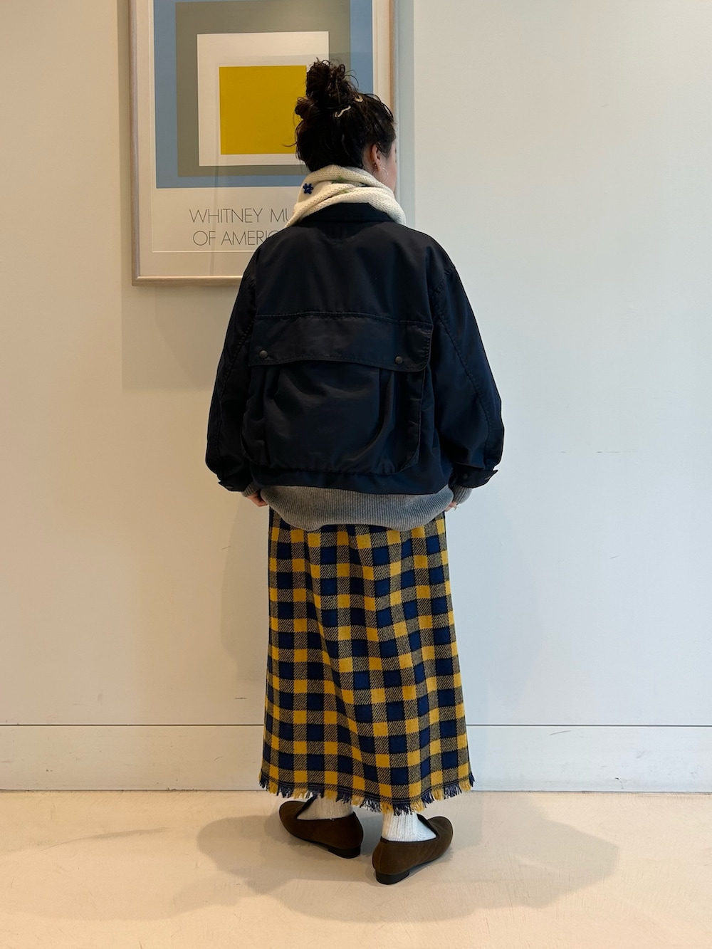 ブルー系のミリタリージャケット、イエロー系のスカート、ブラウン系のドレスシューズを着用したレディースの夏コーディネートの3枚目の写真