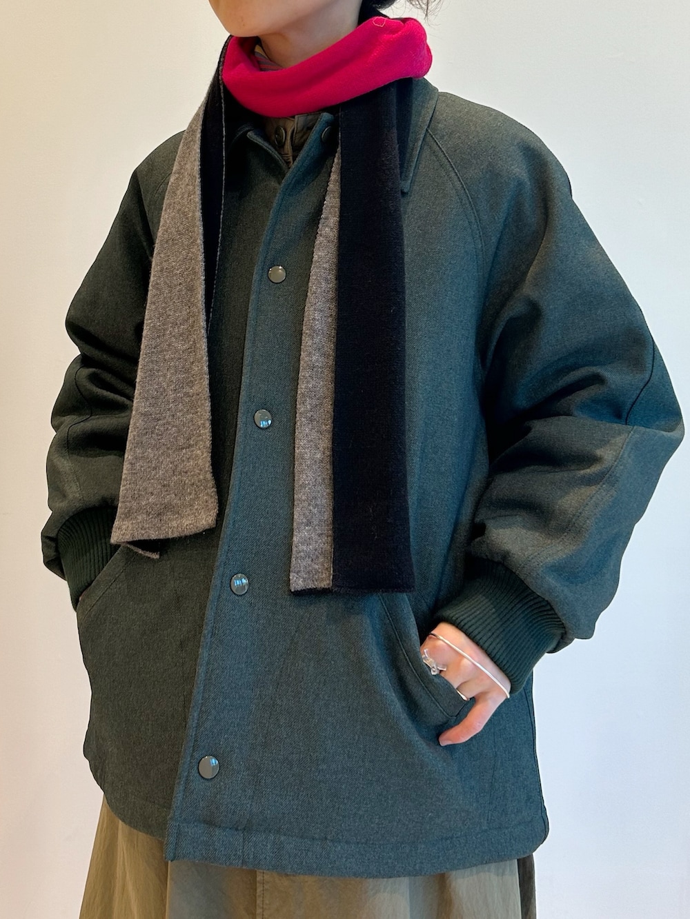 グリーン系のブルゾン、グリーン系のワンピース、イエロー系のTシャツ/カットソーを着用したレディースの秋コーディネートの5枚目の写真