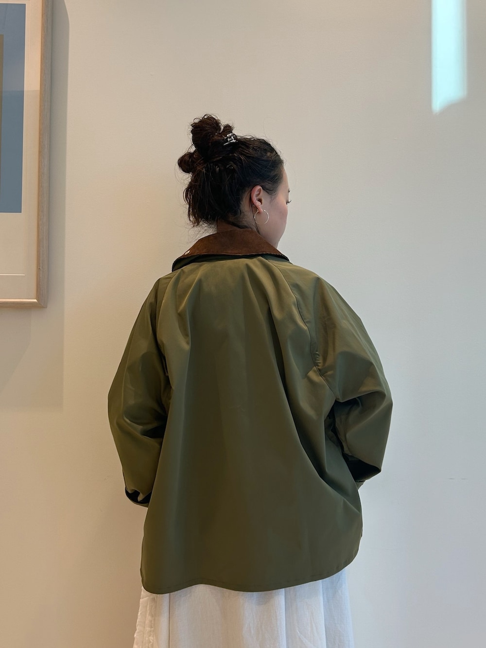 グリーン系のブルゾン、ホワイト系のTシャツ/カットソー、ブルー系のデニムパンツを着用したレディースの冬コーディネートの5枚目の写真