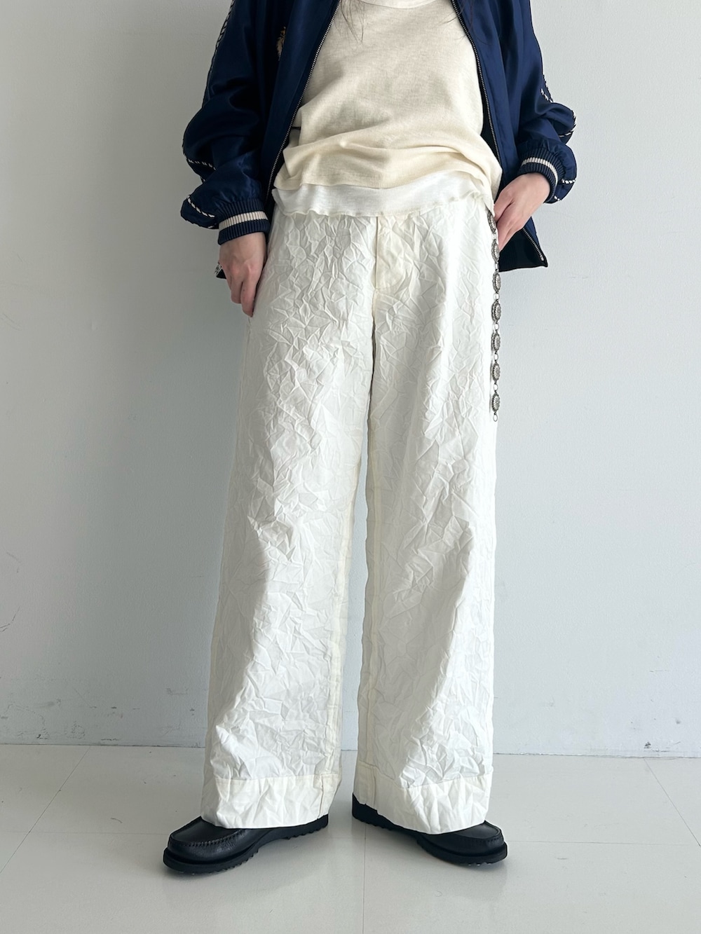 ホワイト系のスラックス、ブルー系のスカジャン、ホワイト系のタンクトップを着用したレディースの春コーディネートの10枚目の写真