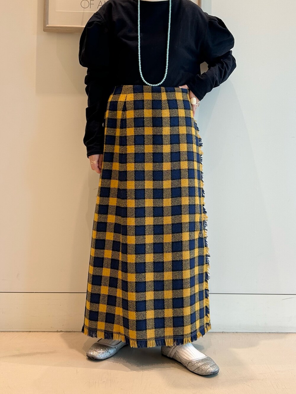 イエロー系のスカート、ホワイト系のカーディガン/ボレロ、ブラック系のメガネを着用したレディースの秋コーディネートの8枚目の写真