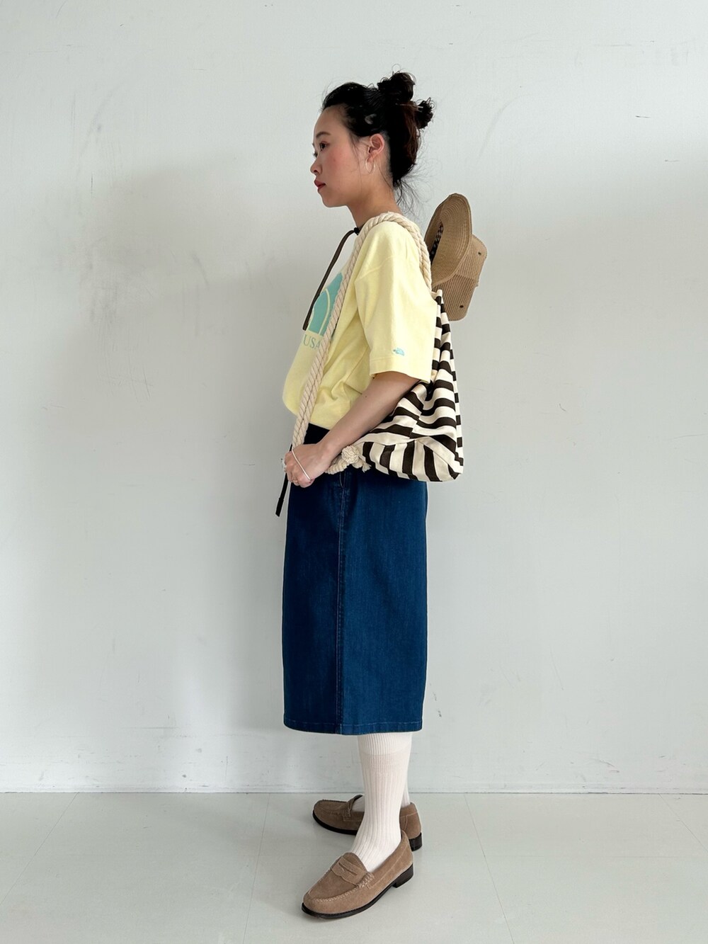 ブラウン系のバックパック/リュック、ブルー系のデニムパンツ、ベージュ系のローファーを着用したレディースの春コーディネートの2枚目の写真