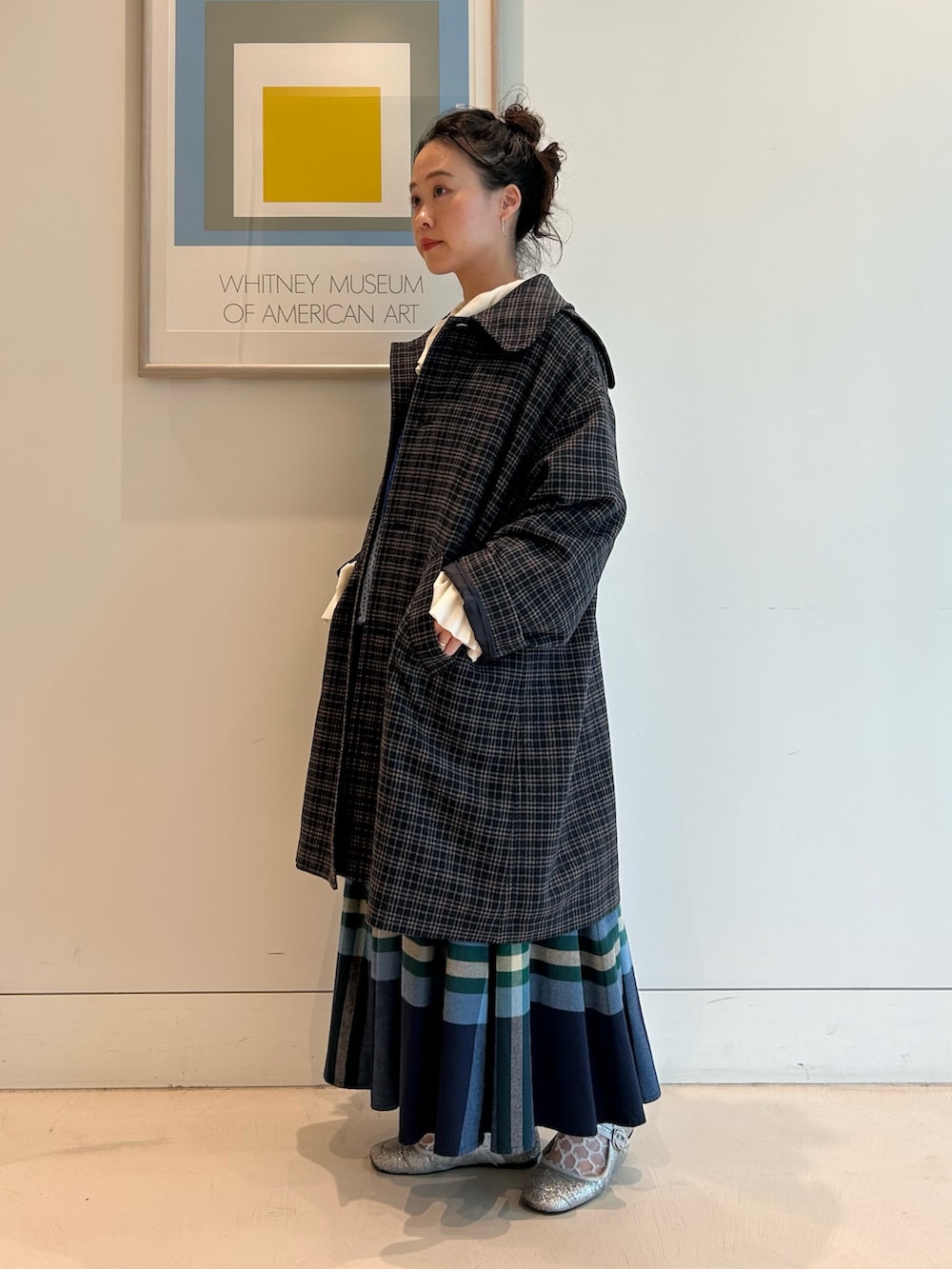 ブルー系のステンカラーコート、ホワイト系のTシャツ/カットソー、ブルー系のカーディガン/ボレロを着用したレディースの秋コーディネートの2枚目の写真