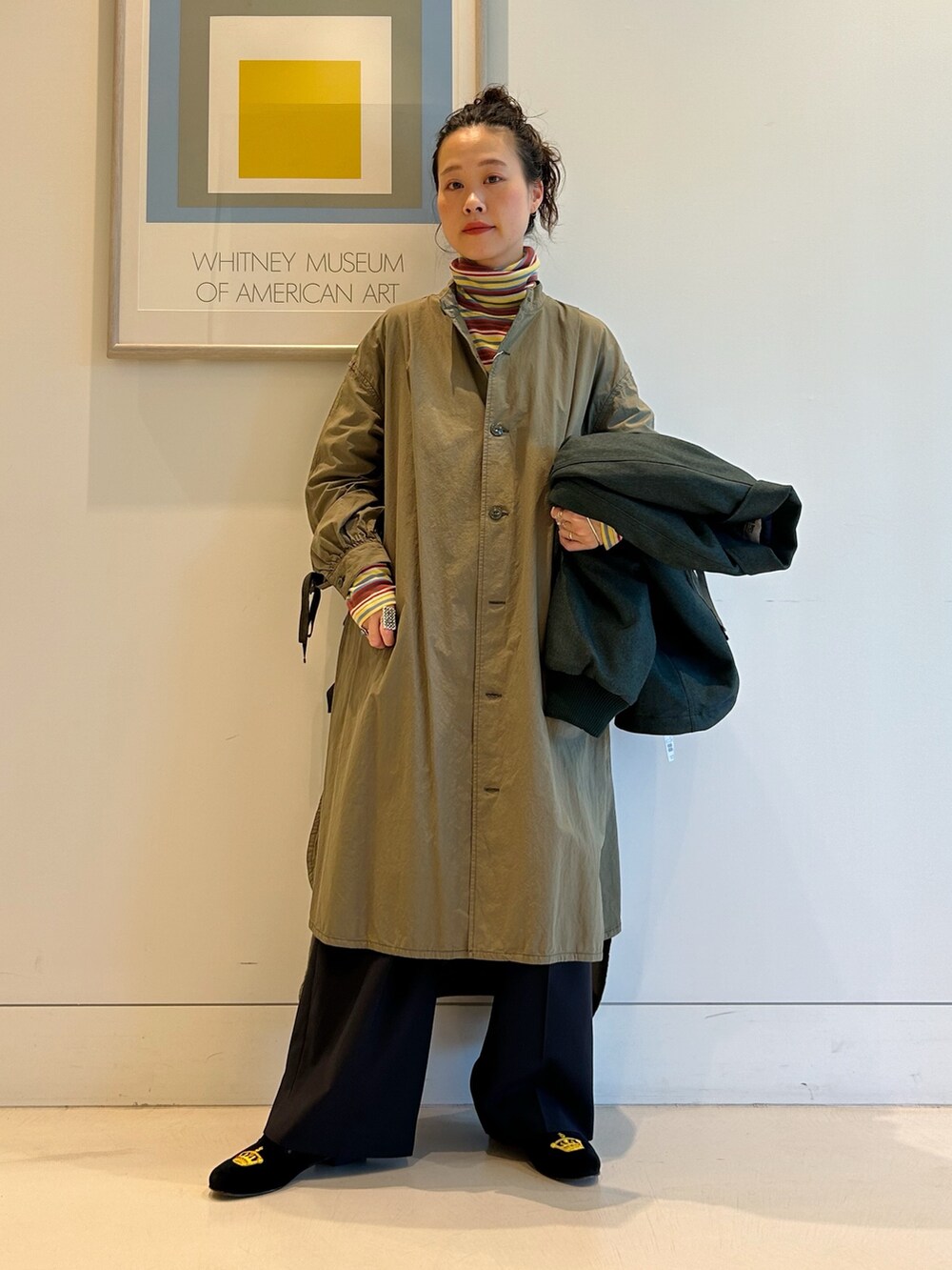 グリーン系のブルゾン、グリーン系のワンピース、イエロー系のTシャツ/カットソーを着用したレディースの秋コーディネートの6枚目の写真