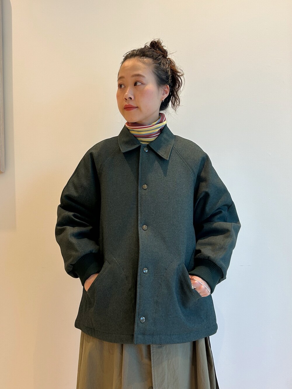 グリーン系のブルゾン、グリーン系のワンピース、イエロー系のTシャツ/カットソーを着用したレディースの秋コーディネートの4枚目の写真