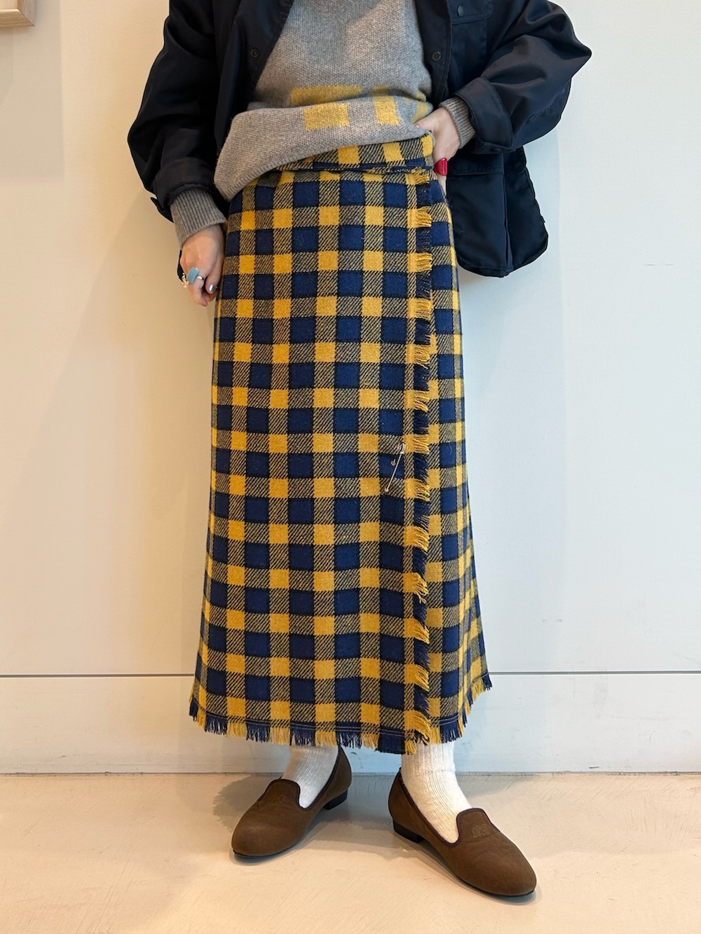 ブルー系のミリタリージャケット、イエロー系のスカート、ブラウン系のドレスシューズを着用したレディースの夏コーディネートの8枚目の写真