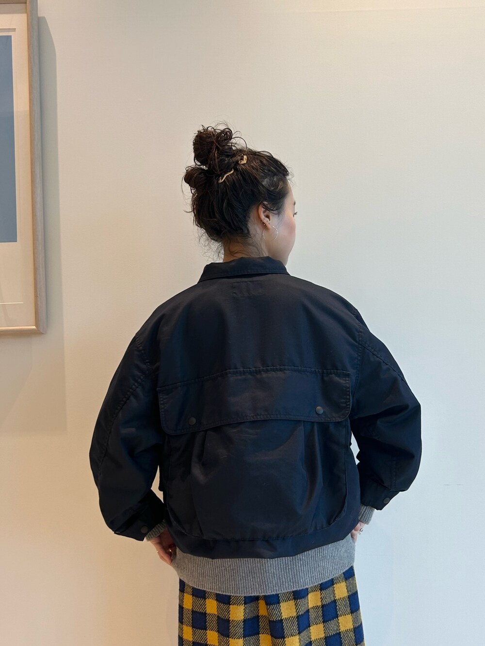 ブルー系のミリタリージャケット、イエロー系のスカート、ブラウン系のドレスシューズを着用したレディースの夏コーディネートの5枚目の写真