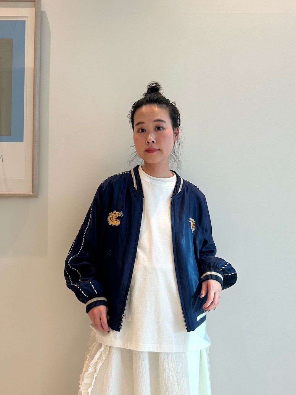 ブルー系のスカジャン、ホワイト系のスカート、ブラック系のローファーを着用したレディースの春コーディネートの3枚目の写真