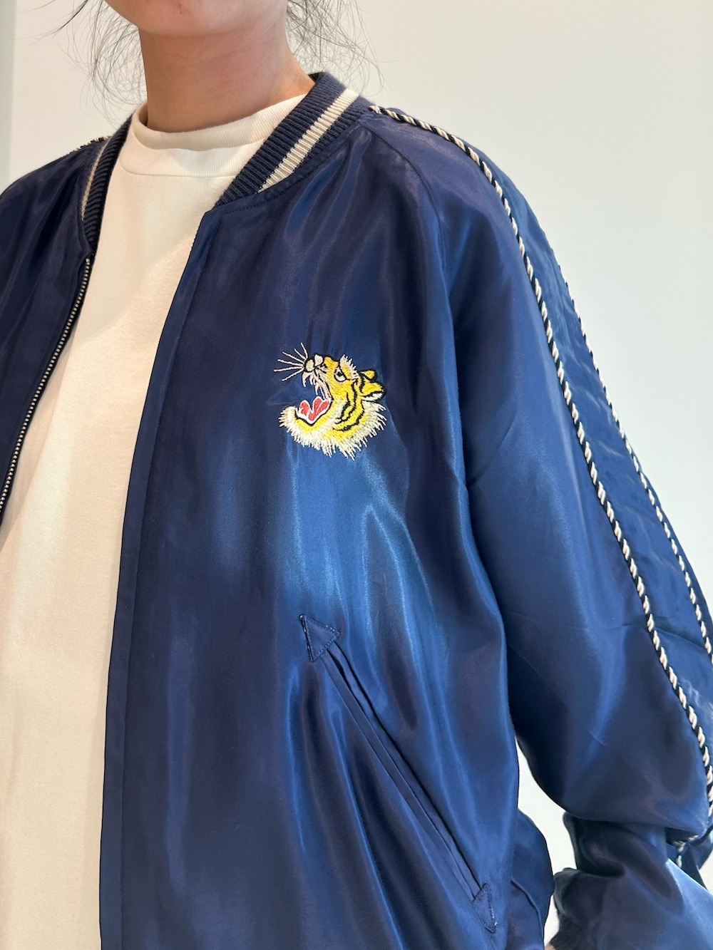 ブルー系のスカジャン、ホワイト系のスカート、ブラック系のローファーを着用したレディースの春コーディネートの5枚目の写真