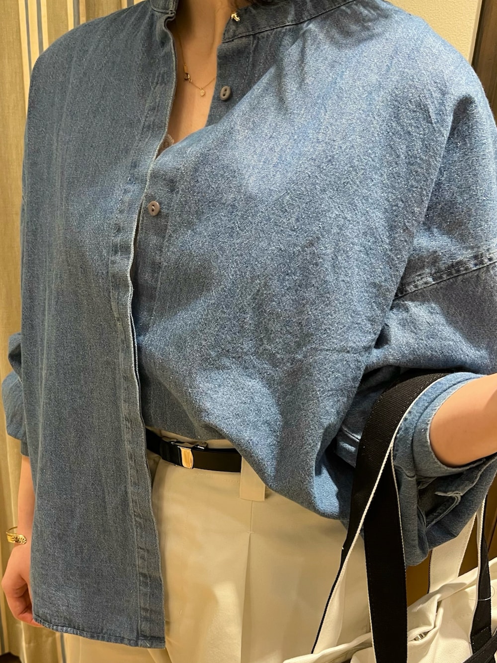 ブルー系のシャツ/ブラウス、ホワイト系のその他パンツ、ブラック系のハンドバッグを着用したレディースの春コーディネートの3枚目の写真