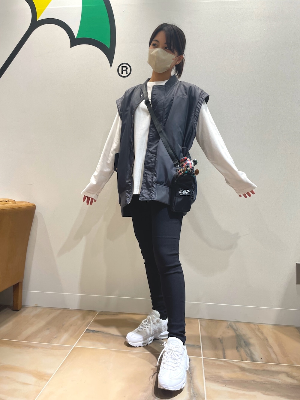 グレー系のブルゾン、ホワイト系のTシャツ/カットソー、ブラック系のショルダーバッグを着用したレディースの秋コーディネートの2枚目の写真