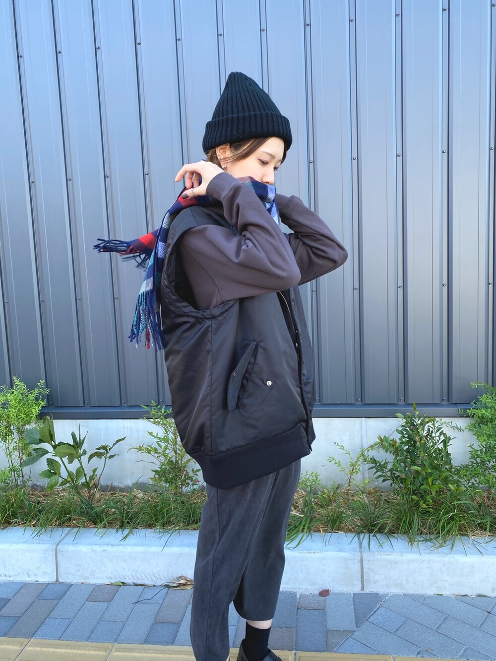 ブラック系のトートバッグ、ブラウン系のパーカー、ブラック系のブルゾンを着用したレディースの秋コーディネートの3枚目の写真