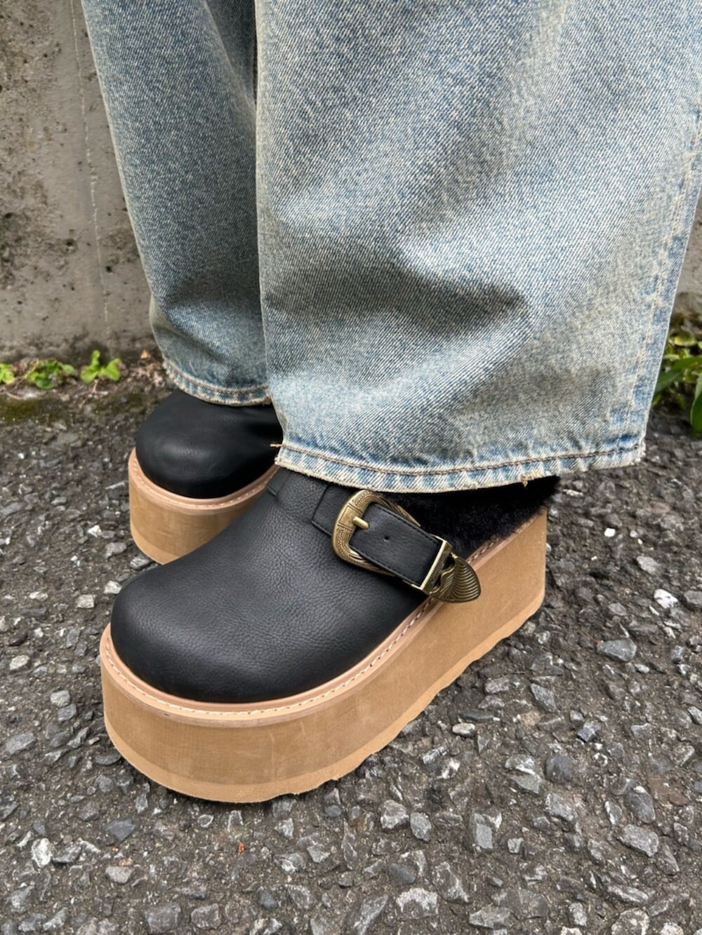 ブラック系のショルダーバッグ、ブラック系のニット/セーター、ブルー系のデニムパンツを着用したレディースの秋コーディネートの9枚目の写真