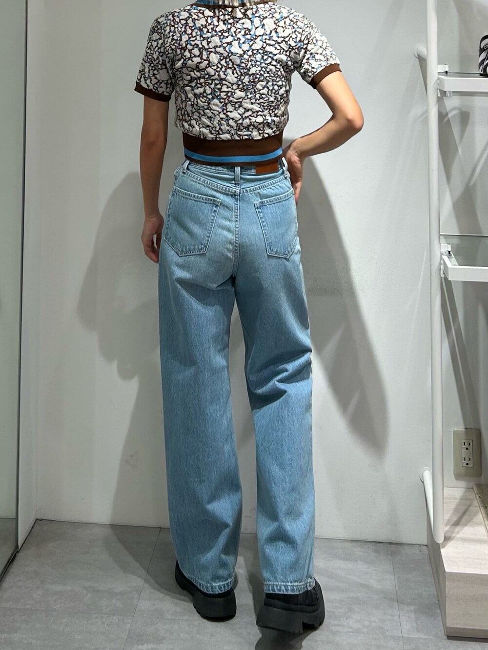 ブルー系のデニムパンツ、ブラウン系のニット/セーターを着用したレディースの春コーディネートの2枚目の写真