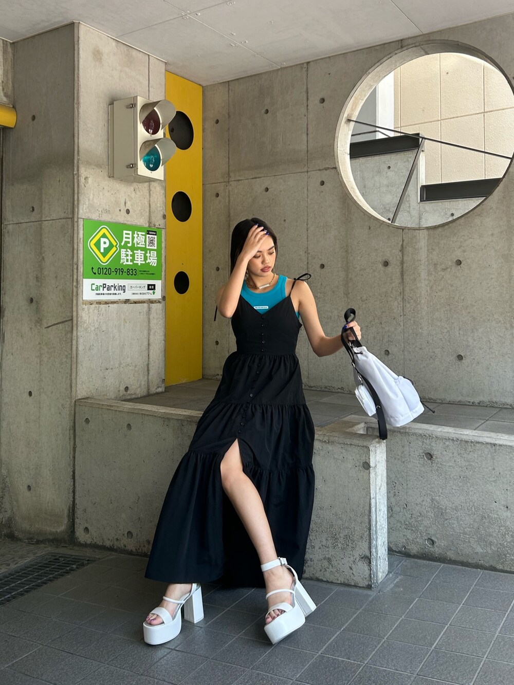 ホワイト系のサンダル、ブラック系のワンピース、ホワイト系のショルダーバッグを着用したレディースの夏コーディネートの2枚目の写真