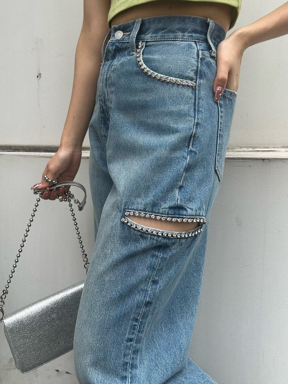 ブルー系のデニムパンツ、グリーン系のTシャツ/カットソー、シルバー系のショルダーバッグを着用したレディースの春コーディネートの2枚目の写真