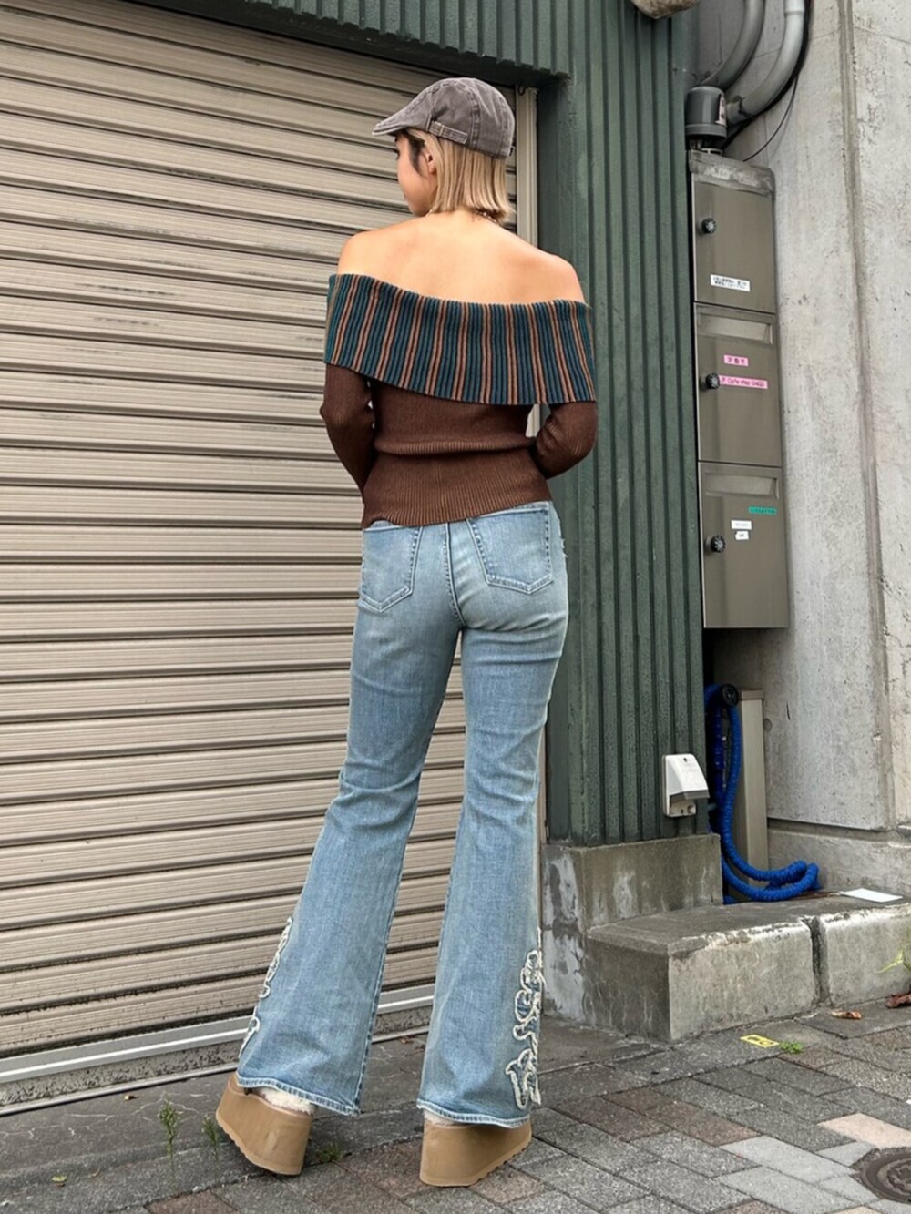 ブラウン系のニット/セーター、ベージュ系のスリッポン、ブルー系のデニムパンツを着用したレディースの秋コーディネートの2枚目の写真