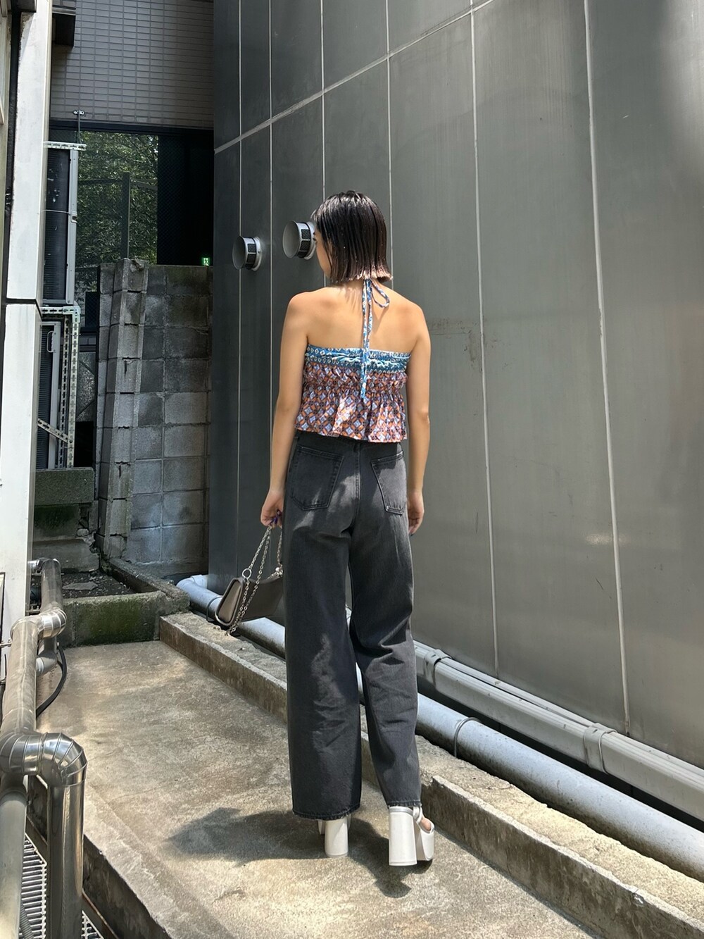 ブルー系のキャミソール、ホワイト系のサンダル、ブラック系のデニムパンツを着用したレディースの夏コーディネートの2枚目の写真