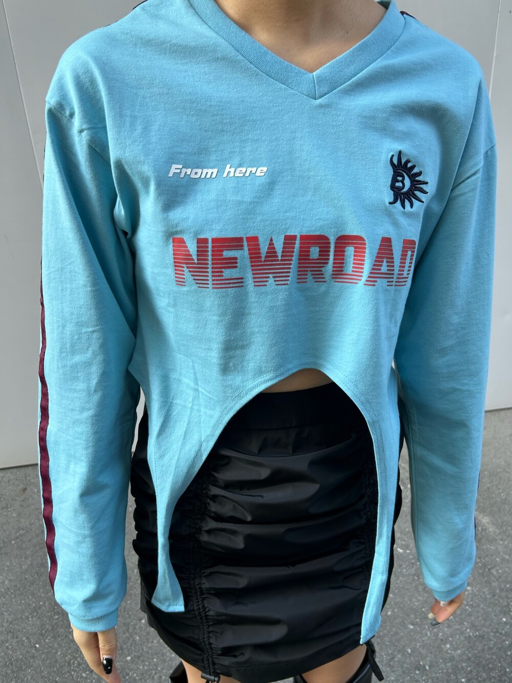 ブラック系のスカート、ブルー系のTシャツ/カットソー、ブラック系のブーツを着用したレディースの冬コーディネートの2枚目の写真