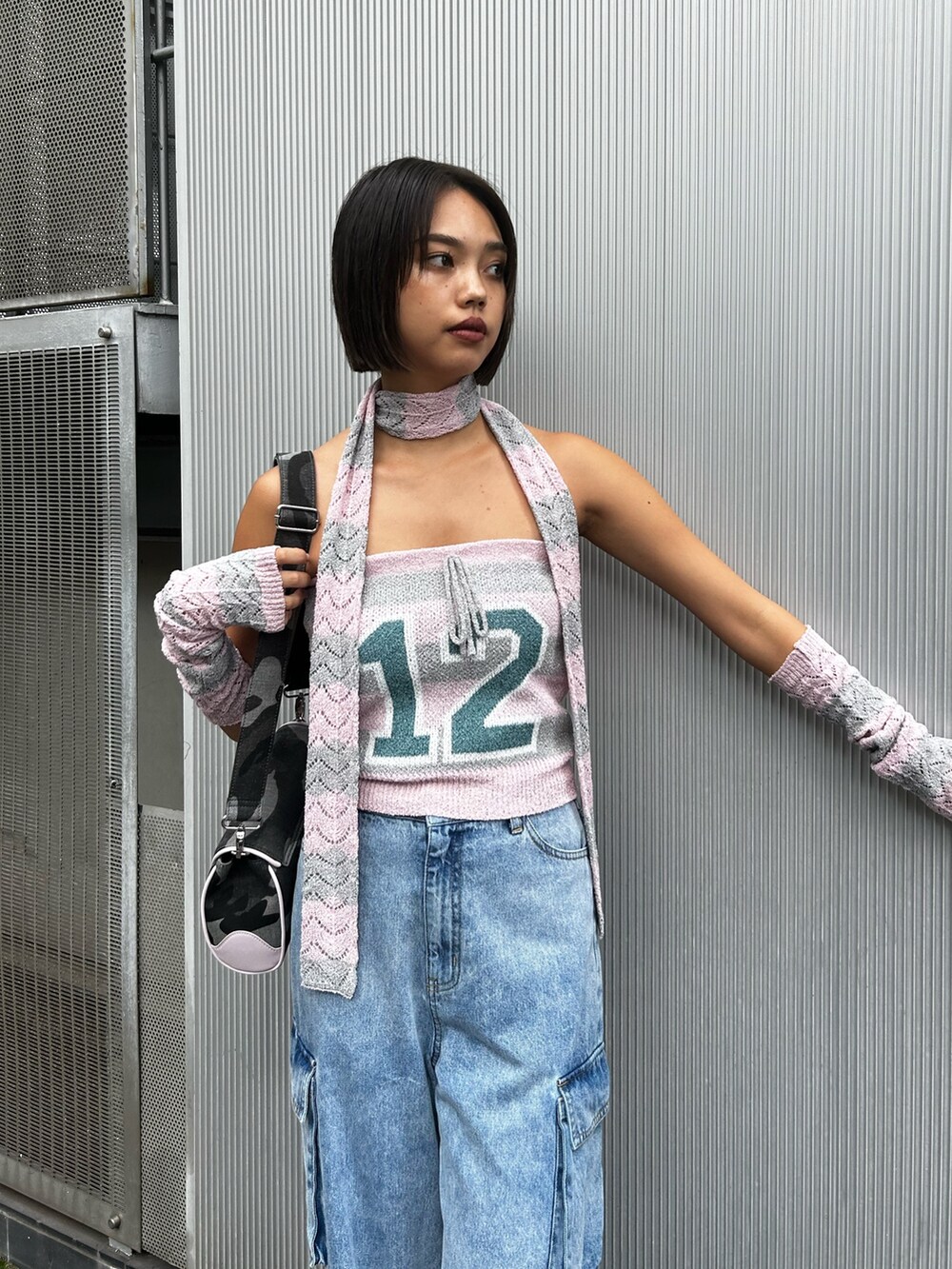 ピンク系のニット/セーター、ブルー系のデニムパンツ、ブラック系のショルダーバッグを着用したレディースの秋コーディネートの3枚目の写真