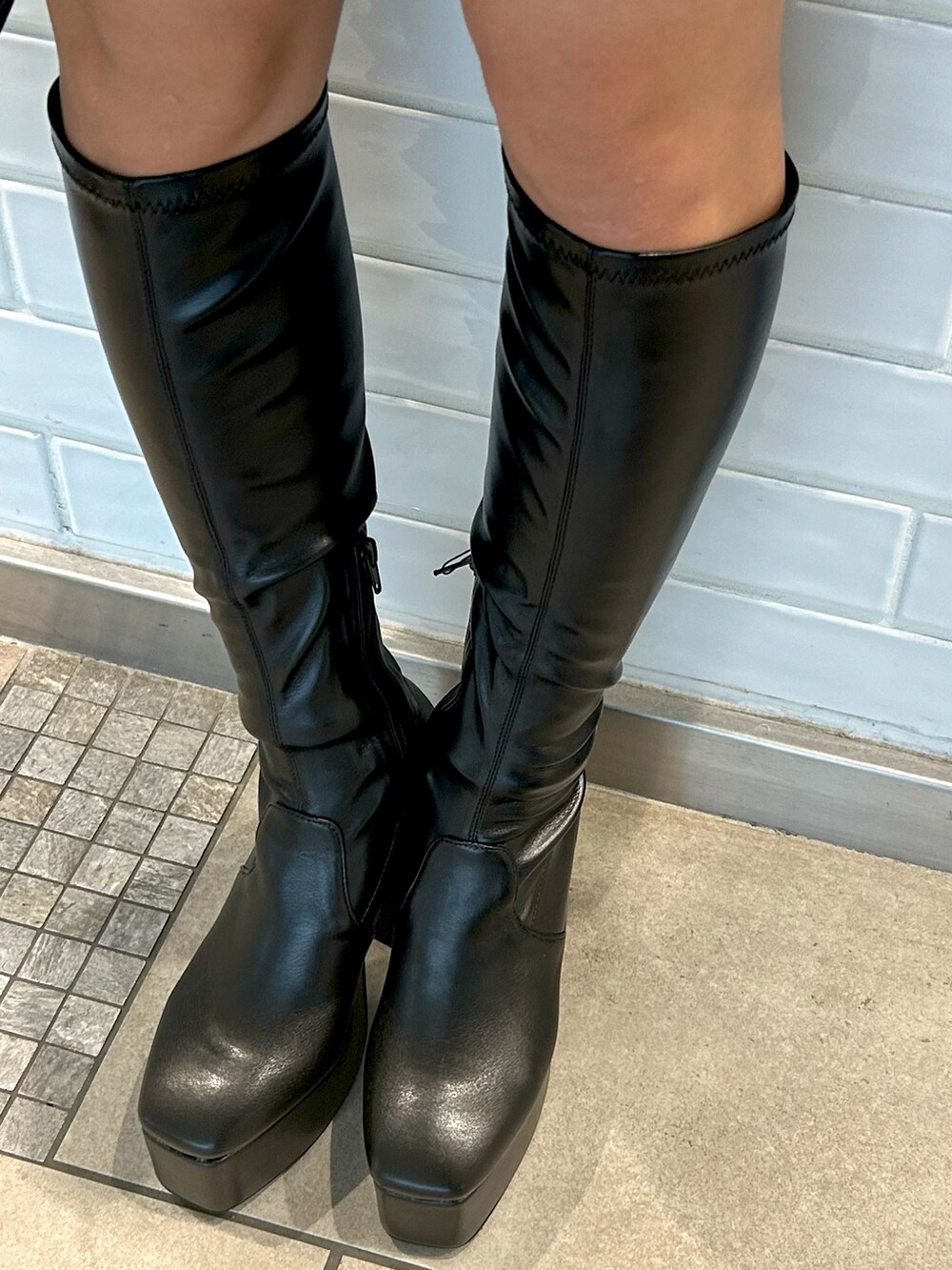 グレー系のテーラードジャケット、グレー系のスカート、ブラック系のハンドバッグを着用したレディースの秋コーディネートの4枚目の写真