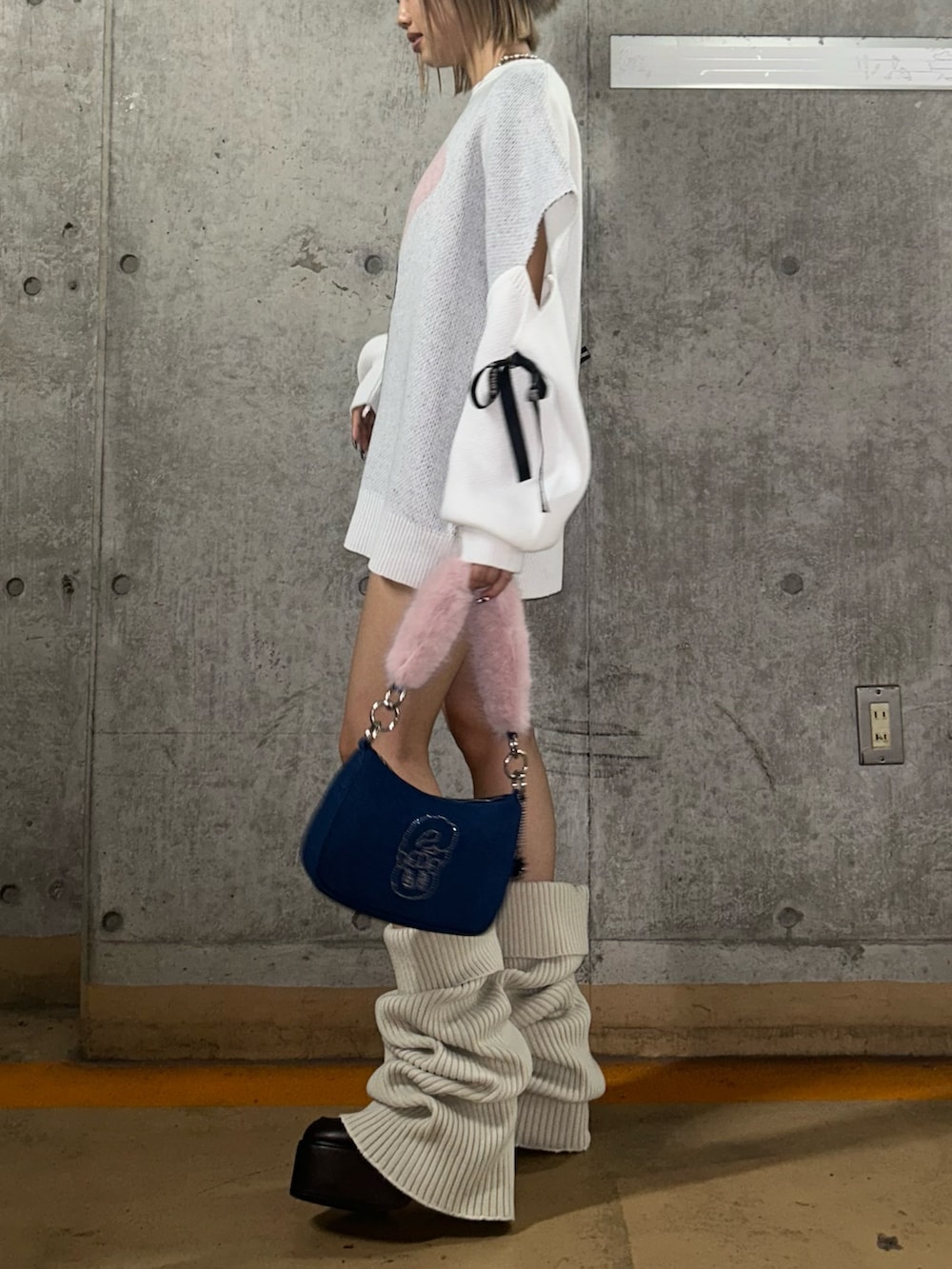 ホワイト系のニット/セーター、ブルー系のハンドバッグ、ブラウン系のブーツを着用したレディースの秋コーディネートの2枚目の写真