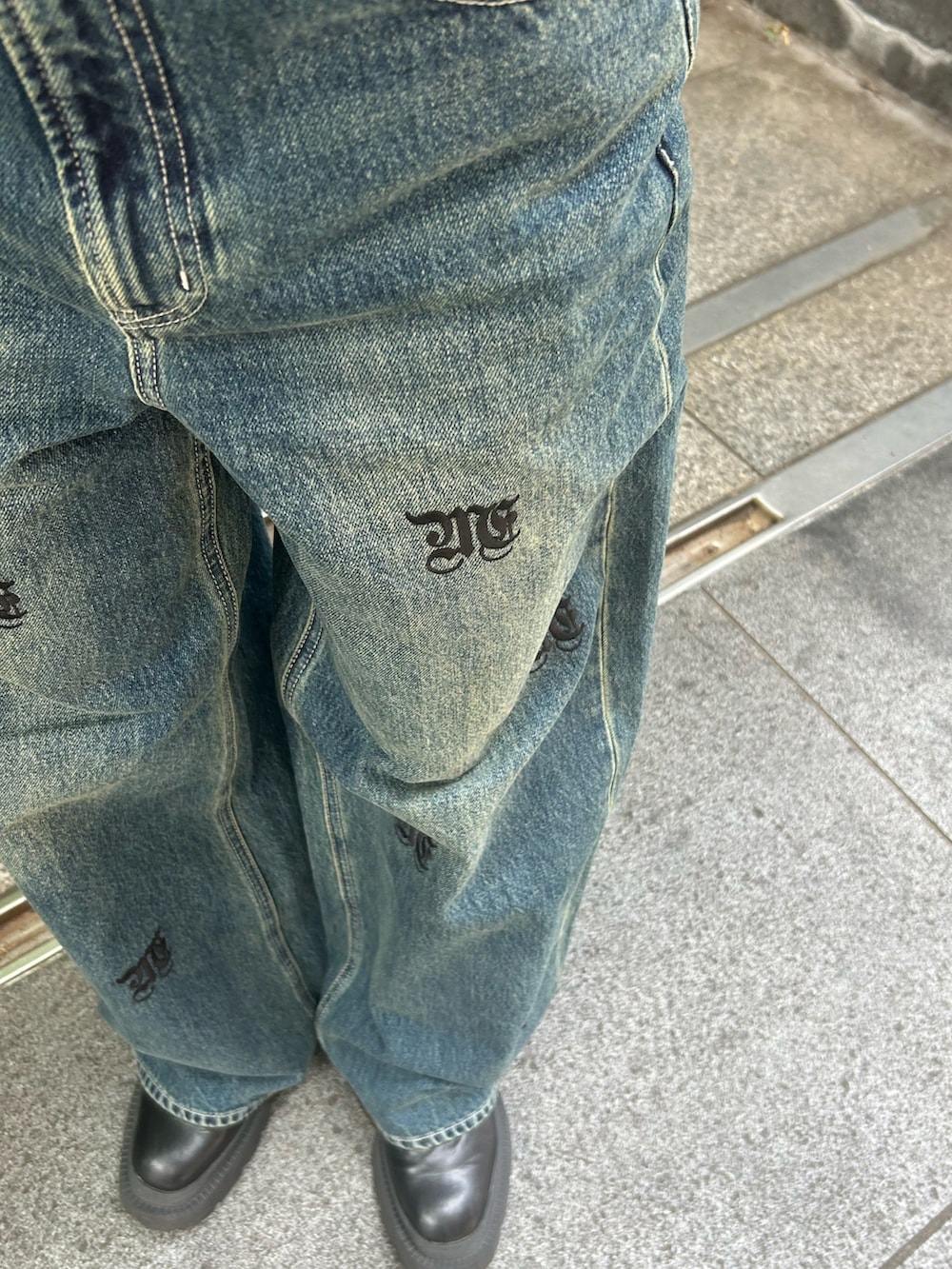 ブルー系のデニムパンツ、ホワイト系のタンクトップ、ブラック系のブーツを着用したレディースの春コーディネートの3枚目の写真