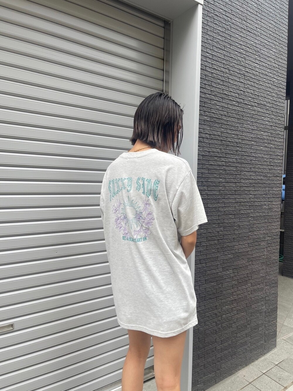 グレー系のTシャツ/カットソー、ブラック系のブーツ、ブラック系のショルダーバッグを着用したレディースの夏コーディネートの3枚目の写真