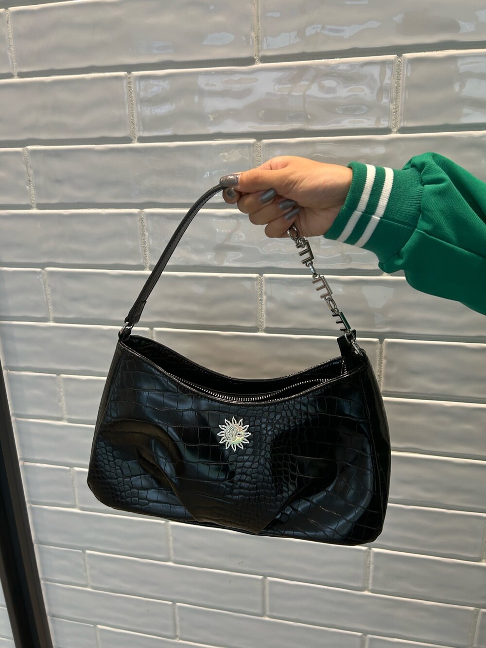 ブルー系のデニムパンツ、グリーン系のテーラードジャケット、ブラック系のハンドバッグを着用したレディースの秋コーディネートの5枚目の写真