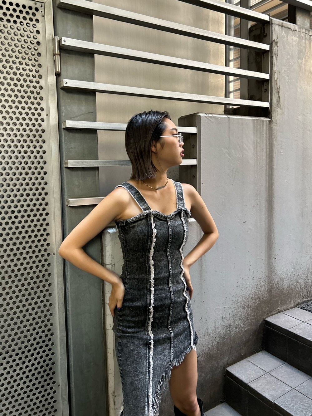 ブラック系のブーツ、ブラック系のワンピースを着用したレディースの夏コーディネートの3枚目の写真