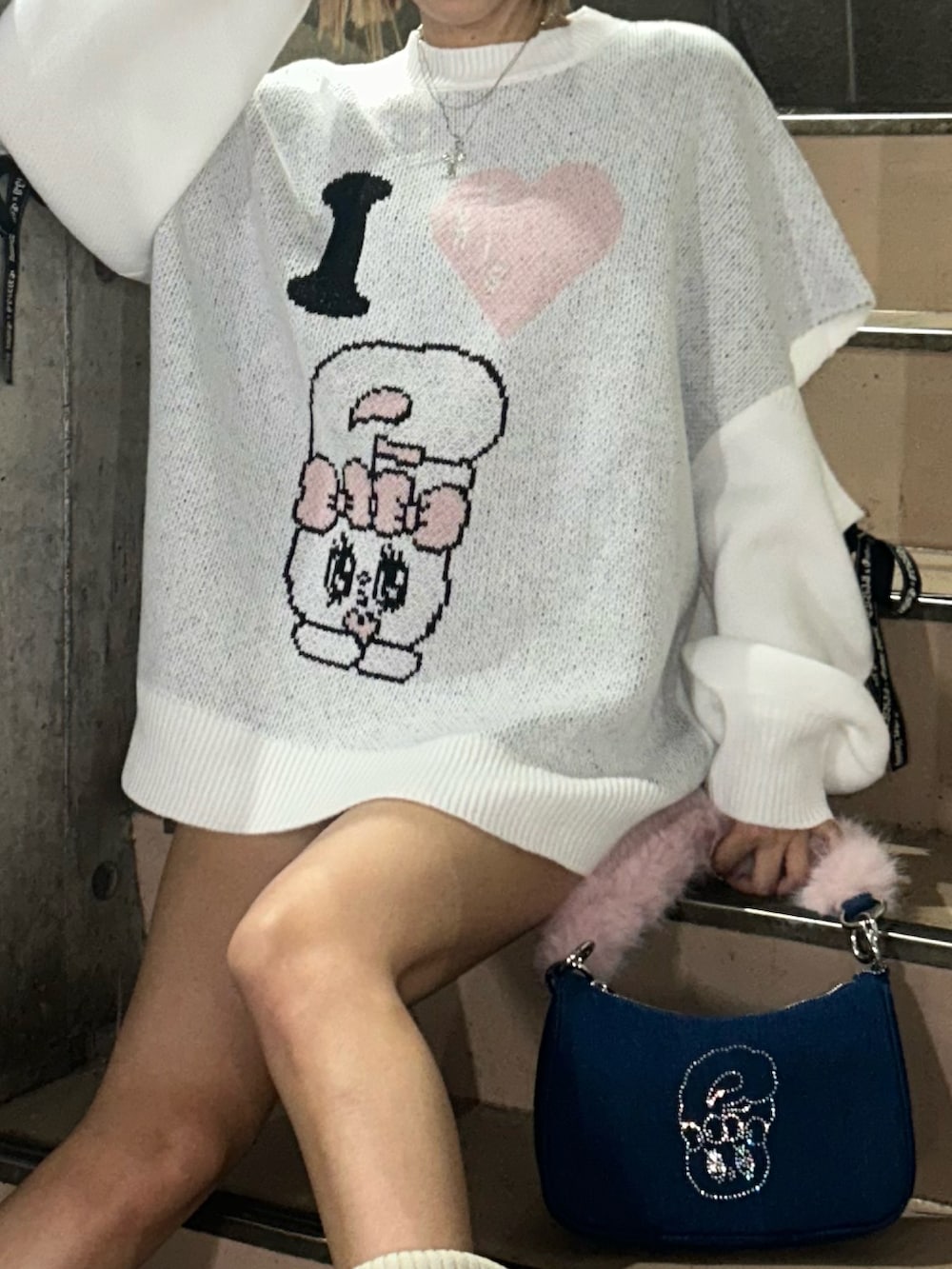 ホワイト系のニット/セーター、ブルー系のハンドバッグ、ブラウン系のブーツを着用したレディースの秋コーディネートの4枚目の写真