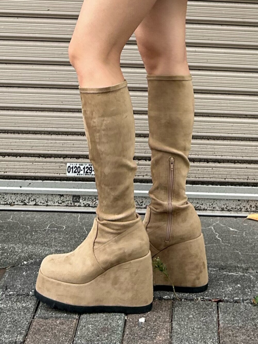 ブルー系のデニムスカート、ブラウン系のニット/セーター、ベージュ系のブーツを着用したレディースの秋コーディネートの7枚目の写真