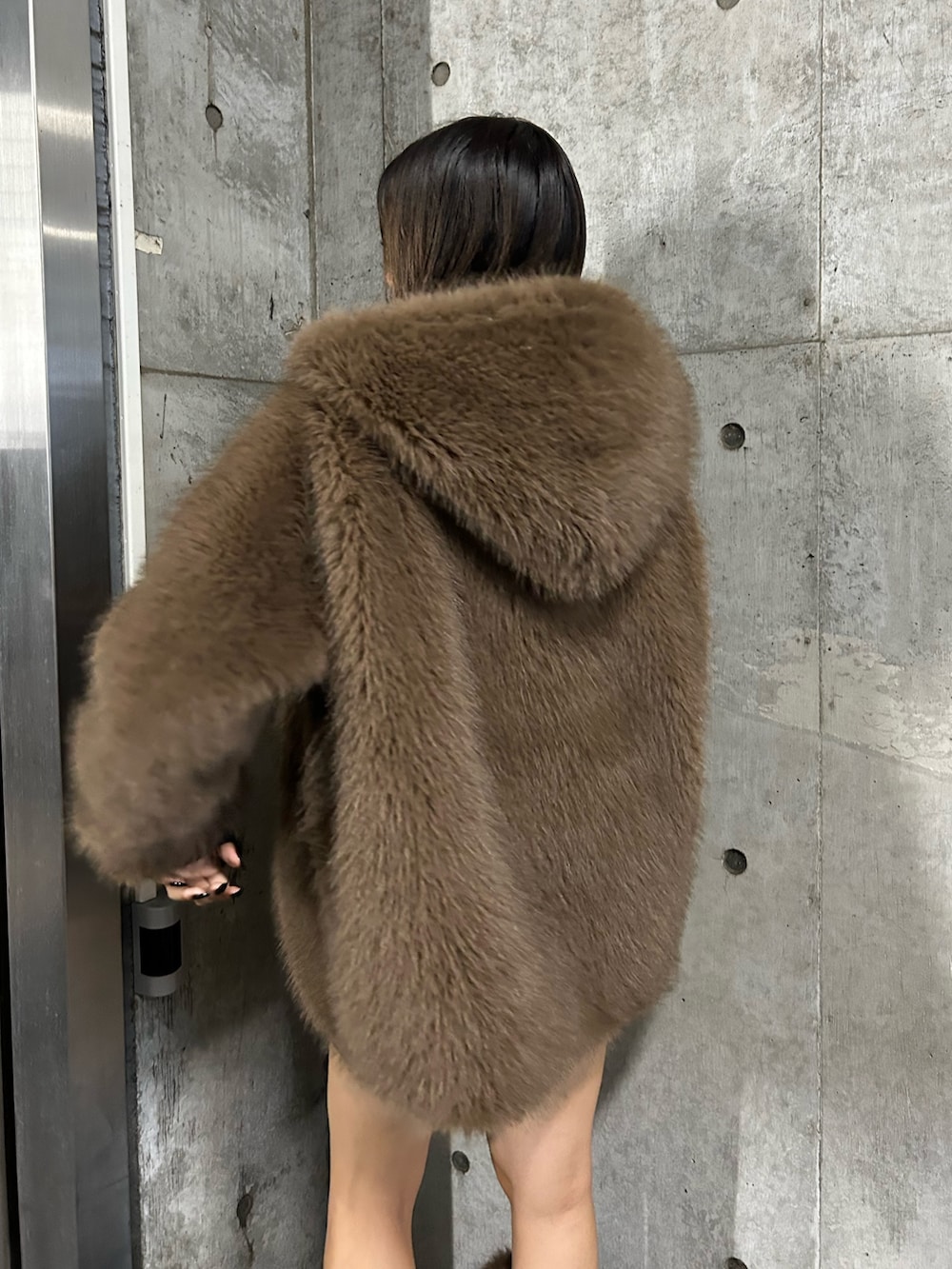 ブラウン系のブルゾン、ブラック系のブーツ、ブラウン系のレッグウォーマーを着用したレディースの秋コーディネートの3枚目の写真