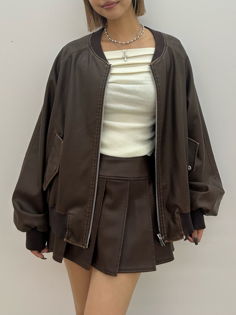 ブラック系のブーツ、ブラウン系のスカート、ブラウン系のブルゾンを着用したレディースの秋コーディネートの4枚目の写真