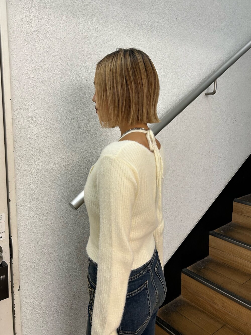 ホワイト系のニット/セーター、ブラック系のショルダーバッグ、ブルー系のデニムパンツを着用したレディースの秋コーディネートの5枚目の写真