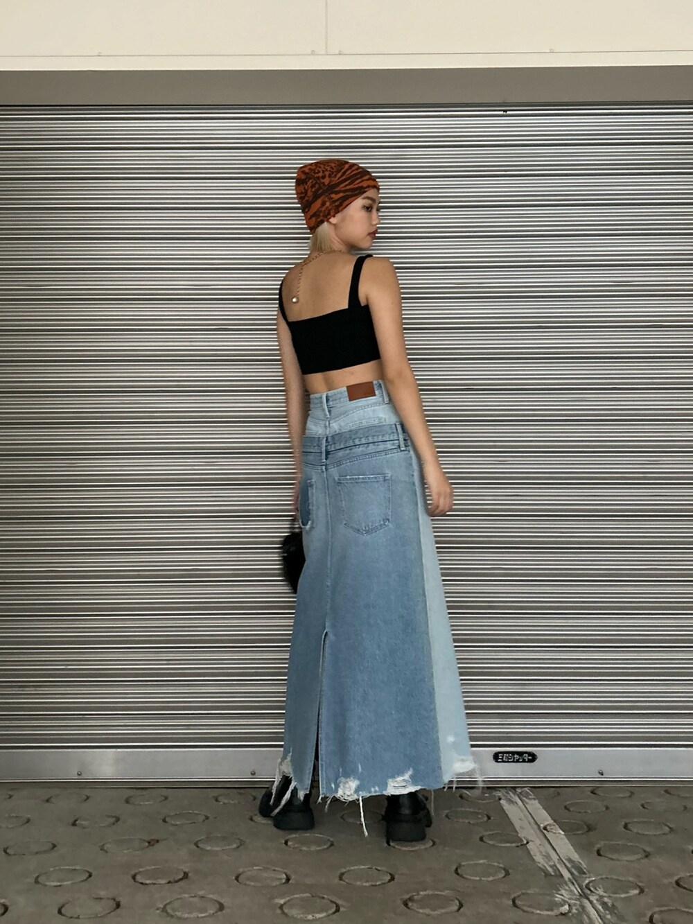 ブラック系のショルダーバッグ、ブラック系のキャミソール、ブラック系のブーツを着用したレディースの春コーディネートの2枚目の写真