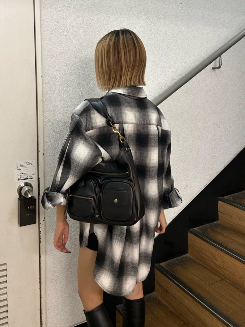 ブラック系のハンドバッグ、ブラック系のブーツ、ブラック系のシャツ/ブラウスを着用したレディースの秋コーディネートの6枚目の写真