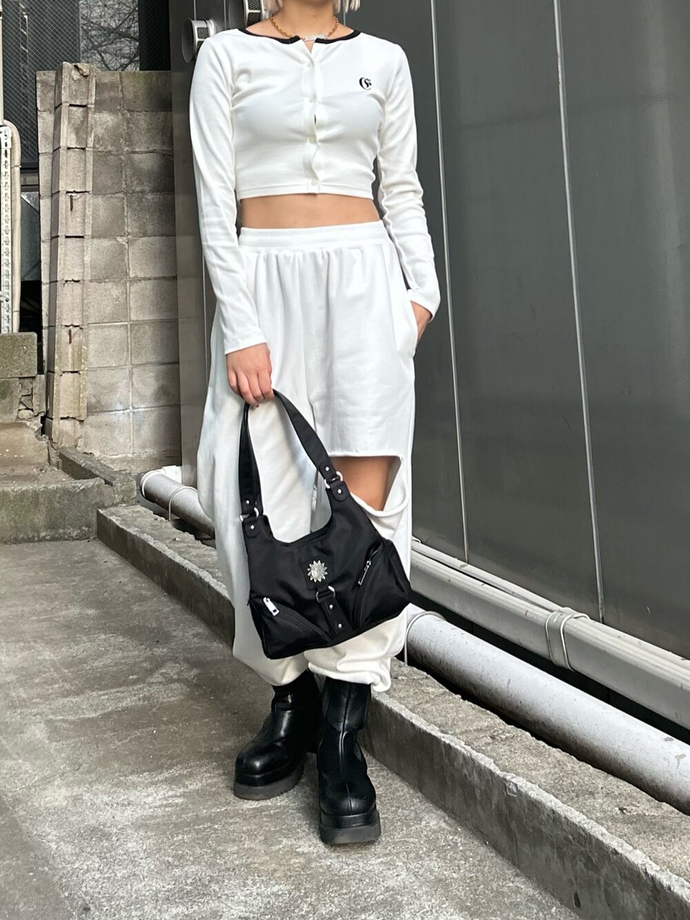 ホワイト系のTシャツ/カットソー、ブラック系のハンドバッグ、ブラック系のブーツを着用したレディースの冬コーディネートの3枚目の写真